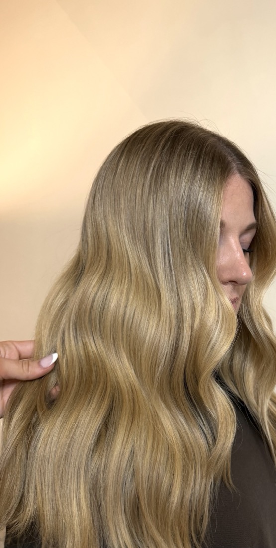 Warm golden blonde waves against a cream backdrop.